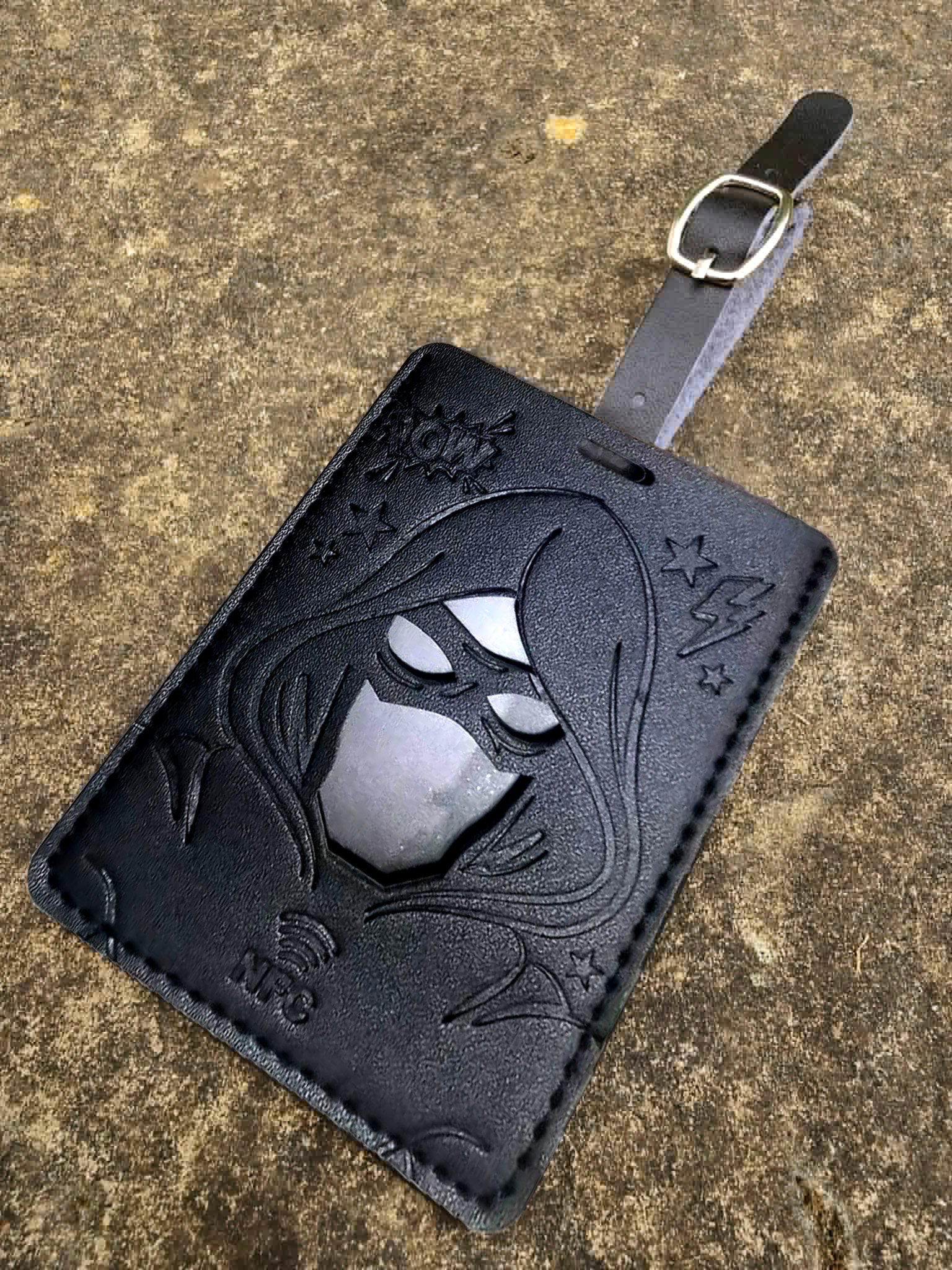 Front of a black BeauTag superhero luggage tag with removable buckle strap